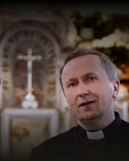 Ks. prof. Ryszard Hajduk w koloratce, w tle ołtarz z krucyfiksem